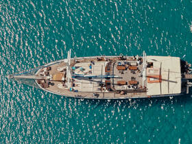 Aerial view of a lively group enjoying their time aboard a yacht, surrounded by sparkling turquoise waters — perfect for celebrations and group outings.