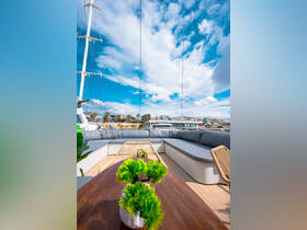 A beautifully designed lounge area on a yacht, featuring comfortable seating and decorative plants, perfect for relaxing while enjoying the views.