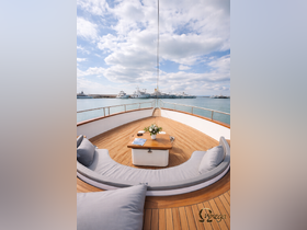 A beautifully designed lounge area on a yacht, featuring comfortable seating and a stylish table, perfect for relaxation while enjoying views of the marina.
