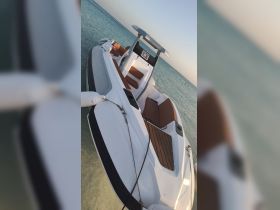 A sleek speedboat docked in clear waters, showcasing its modern design and comfortable seating — perfect for a day out on the water.