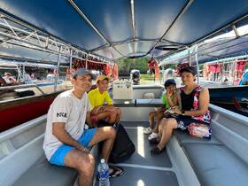 A family enjoys their time inside a boat cabin, showcasing the comfortable seating and vibrant atmosphere, perfect for a day of adventure on the water.
