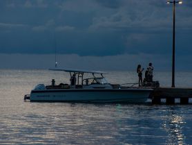 A couple enjoys a quiet moment on the dock beside a boat at dusk, creating a romantic atmosphere perfect for evening outings.