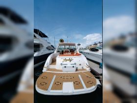 A stunning view of the back of the 'Mr. Lucky' yacht docked at the marina, showcasing its elegant design and spacious deck.