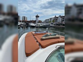 A cozy lounge area on the deck of a yacht, featuring plush cushions, perfect for relaxing while enjoying views of the marina.