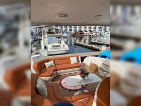 A cozy interior view of a boat's lounge area featuring comfortable seating and a decorative table, perfect for relaxing on the water.