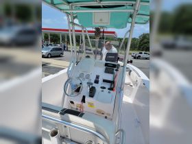 An interior view of a boat's helm and console, showcasing the controls and instruments, with a person inspecting the area.