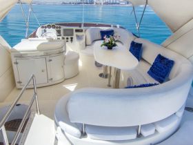 A stylish interior view of a boat's helm and seating area, featuring plush cushions and a modern design, perfect for relaxing while cruising on the water.