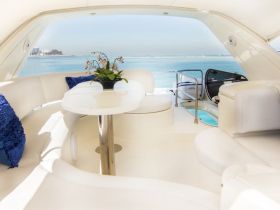 A beautifully designed interior of a boat featuring comfortable seating and a table, perfect for relaxing while enjoying scenic views of the water.