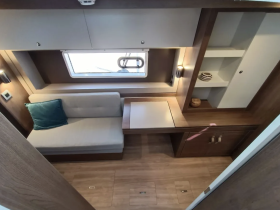 A cozy interior view of a boat cabin featuring comfortable seating and storage, perfect for relaxing during your nautical adventures.