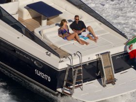 A couple enjoys sunbathing on the deck of a luxurious yacht, showcasing the perfect setting for relaxation on the water.