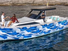 A couple enjoys a toast with cocktails aboard a stylish yacht, capturing a moment of celebration on the water.