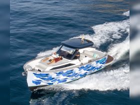 A couple relaxes on the deck of a stylish boat as it cruises through the water, showcasing a perfect day on the sea.