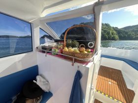 A well-stocked basket of fresh fruits and snacks displayed inside a boat, perfect for enjoying while cruising on the water.