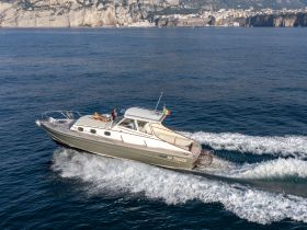 A stylish yacht cruises through sparkling waters, showcasing stunning coastal scenery — perfect for a day of adventure on the sea.