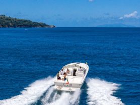 A lively group enjoys a thrilling ride on a speedboat, cutting through the vibrant blue ocean — perfect for adventure seekers and water enthusiasts.