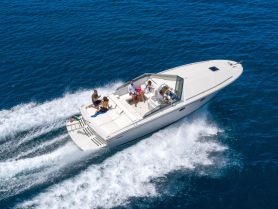A lively group enjoys a day on the water aboard a sleek boat, showcasing the thrill of cruising through vibrant blue seas.