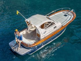 A couple enjoys a sunny day on their boat, showcasing a perfect blend of relaxation and celebration on the water.