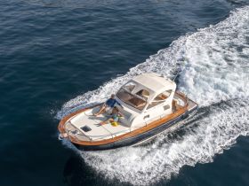 A couple relaxes on a cruising boat, enjoying the open water and sunshine — a perfect moment for adventure seekers and boat lovers.