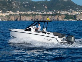 A sleek speedboat named Protagon glides through the sparkling waters, showcasing its modern design and performance on a sunny day.
