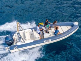 A lively group enjoys a thrilling ride on a speedboat, showcasing the excitement of on-water adventures in crystal-clear waters.