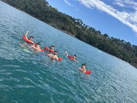 A lively group enjoys snorkeling in clear waters, showcasing the fun and excitement of underwater exploration.