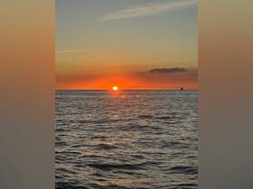 A stunning sunset over the ocean, casting vibrant colors across the water — a perfect backdrop for evening boat cruises.