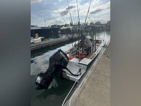 A fishing boat named 'Quepos' is docked, with fishing gear set up and a person preparing for a day on the water. Ideal for anglers looking to explore local waters.