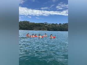 A group of friends enjoys snorkeling in clear waters, showcasing a fun day of swimming and adventure in a beautiful ocean setting.