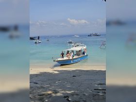 A group of guests disembarks from a boat on a beautiful beach, ready to enjoy a day of sun and fun in the crystal-clear waters.