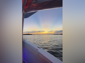 A serene sunset view from the side of a boat, showcasing the tranquil waters and vibrant sky — perfect for evening cruises.