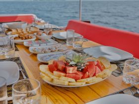 A beautifully arranged spread of fresh fruits and snacks on a boat table, perfect for enjoying a delightful meal while cruising on the water.