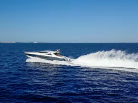 A sleek speedboat glides through the deep blue waters, showcasing its dynamic design and performance on the open sea.