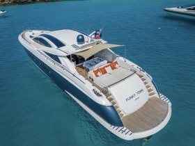 A stunning aerial view of the luxurious yacht 'FUNKY TOWN' anchored in crystal-clear waters, showcasing its elegant design and spacious deck.