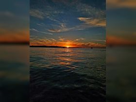 A stunning sunset over calm waters, capturing the serene beauty of nature — perfect for evening boat cruises.