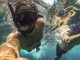 Two snorkelers explore the vibrant underwater world, showcasing the excitement of marine adventures. Perfect for those seeking unforgettable experiences in crystal-clear waters.