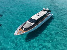 A stunning aerial view of a luxurious yacht cruising through crystal-clear turquoise waters, perfect for upscale charters and island adventures.