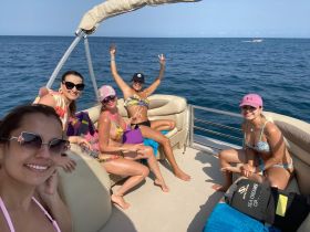A fun group of friends enjoys a sunny day on a pontoon boat, capturing joyful moments on the water — perfect for summer outings and celebrations.
