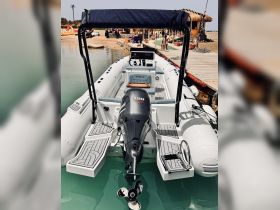 A sleek speedboat is docked in clear waters, showcasing its modern design and features, perfect for thrilling water adventures.