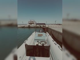 A well-equipped interior view of a sleek boat featuring comfortable seating and a modern helm, perfect for leisurely outings on the water.