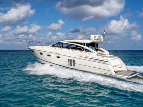 A sleek yacht cruising through clear turquoise waters, showcasing its elegant design and speed — perfect for luxury boating experiences.