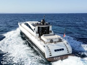 A stunning aerial view of a sleek yacht cruising through clear blue waters, showcasing its elegant design and perfect for luxury charters.