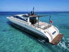 A stunning aerial view of a luxurious yacht cruising through crystal-clear waters, showcasing its sleek design and elegance — perfect for upscale boating experiences.