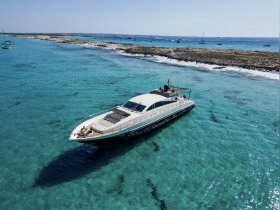 A stunning aerial view of a luxurious yacht cruising through crystal-clear waters, showcasing the beauty of the coastline and the vibrant marine environment.