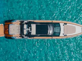 A stunning aerial view of a luxurious yacht cruising through crystal-clear turquoise waters, perfect for showcasing high-end boating experiences.
