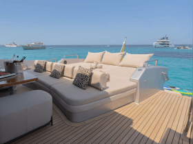 Luxurious lounge area on a yacht featuring plush seating and stunning views of the turquoise waters, perfect for relaxation and entertaining guests.