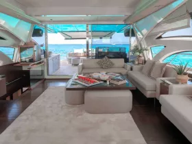 A beautifully designed interior of a luxury yacht featuring a spacious lounge area with comfortable seating and stunning views of the ocean, perfect for relaxation and entertaining guests.