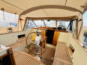 A well-designed helm area of a boat featuring wooden accents and ample seating, perfect for navigating the waters in comfort.