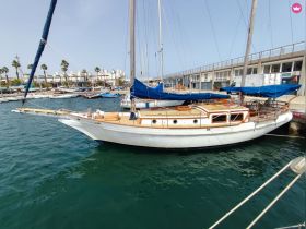 A beautiful sailboat docked at the marina, showcasing its elegant design and wooden accents, perfect for sailing enthusiasts.