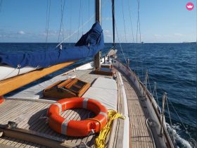 A stunning view of a sailboat's deck, showcasing its elegant design and the serene ocean backdrop — perfect for sailing enthusiasts and maritime photography.