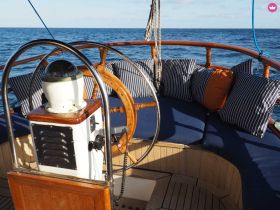A cozy helm area on a boat featuring comfortable seating and navigational equipment, perfect for enjoying a day on the water.